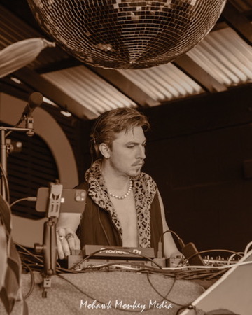 James Blonde DJing beneath a disco ball